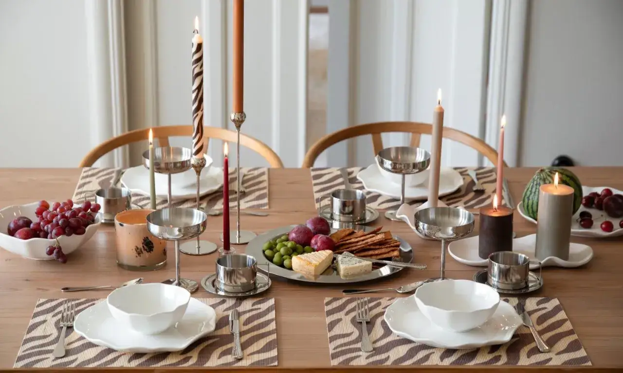 Vackert dukat bord med zebrastripade underl&auml;gg, frukt, ost och t&auml;nda ljus. En perfekt duka bord inspiration f&ouml;r en mysig kv&auml;ll.