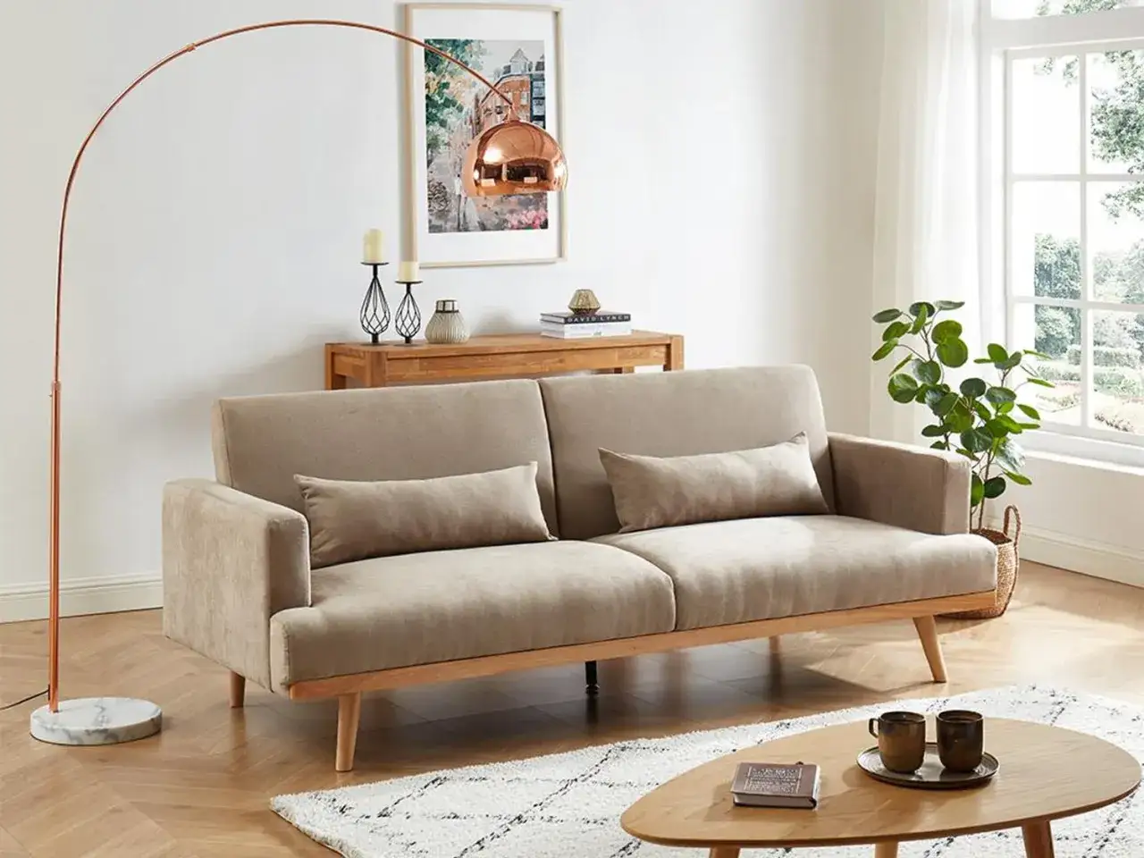 En ljus soffa med trädetaljer, en kopparlampa och en tavla. En tidlös design klassiker som skapar en mysig atmosfär.