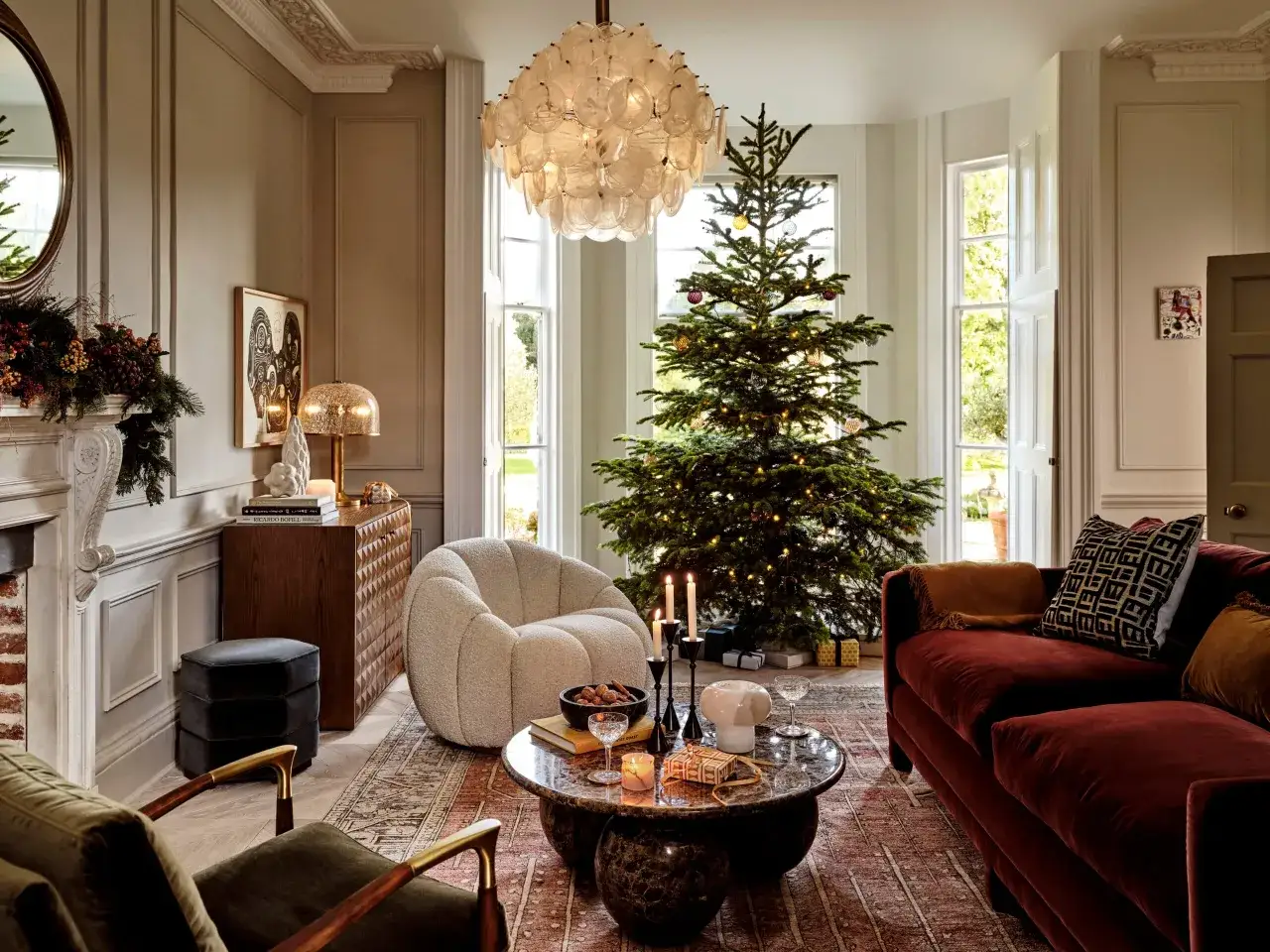 Ett vardagsrum redo för en mysig jul med julgran, levande ljus och presenter.